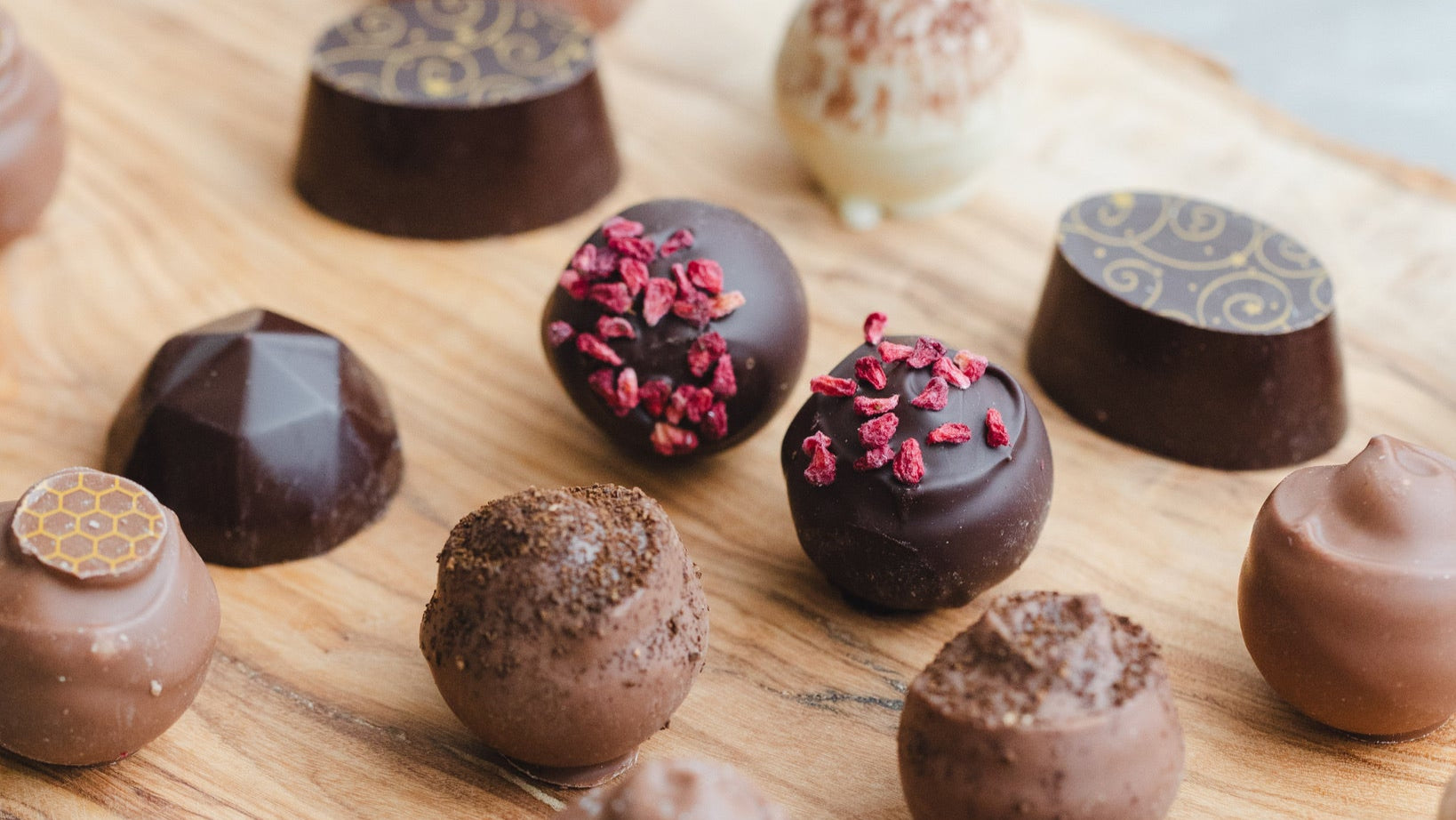 assortment of cococaramel chocolates on wooden board 